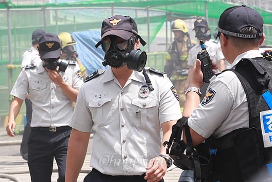  13일 오전 서울 종로구 경복궁 옆 국립현대미술관 신관 신축공사장에서 화재가 발생, 출동한 소방대원과 경찰이 화재로 인한 유독가스 때문에 방독면을 착용하고 구조작업을 벌이고 있다.