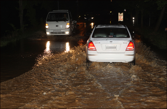 지난 12일 밤 소원면의 모습. 물이 범람한 도로위로 차량이 이동하고 있다.