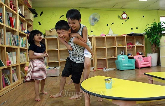 13일 오후 서울 동작구 상도동 성대골 마을학교에서 황서준이 알까기 놀이에 져서 친구 형을 업고 뛰는 벌칙을 수행하고 있다.
