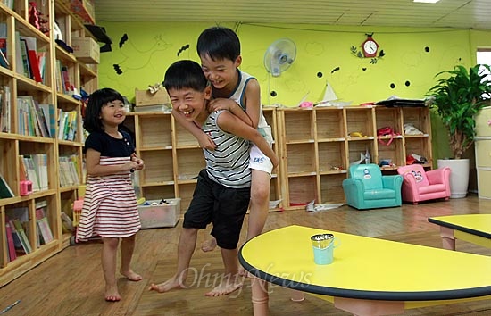  13일 오후 서울 동작구 상도동 성대골 마을학교에서 황서준이 알까기 놀이에 져서 친구 형을 업고 뛰는 벌칙을 수행하고 있다.
