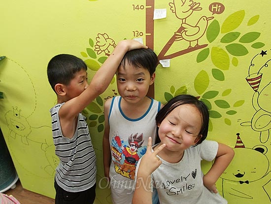 13일 오후 서울 동작구 상도동 성대골 마을학교에서 아이들이 서로 키를 재고 있다. 벽면에 그려진 그림은 마을 어머니들이 손수 디자인하고 페인트로 색칠해 꾸며놓았다.