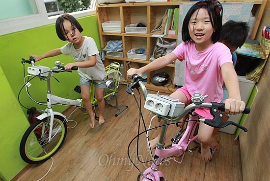 13일 오후 서울 동작구 상도동 성대골 어린이 도서관에서 어린이들이 페달을 돌려 전기를 만드는 자전거 발전기를 타고 놀고 있다.
