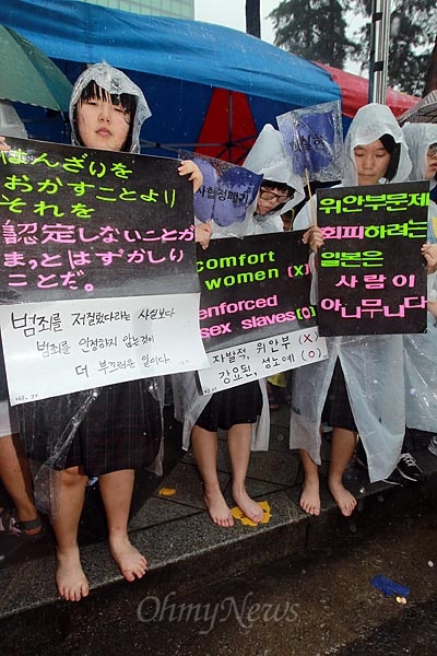  일본의 사죄를 요구하는 피켓을 든 여중생들이 폭우속에 맨발로 참석하고 있다.