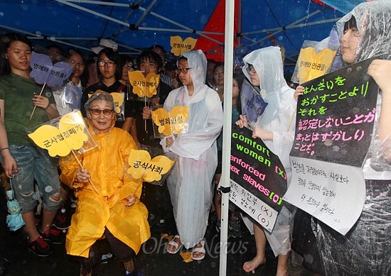 수요시위에 참석한 김복동 할머니 주위에 일본의 사죄를 요구하는 피켓을 든 학생들이 둘러 서 있다.