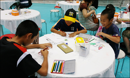 국제만화박람회에서 그림을 그리고 있는 아이들