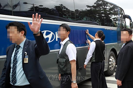 23일 오전 서울 양재동 현대기아차그룹 본사앞에서 '비정규직 없는 일터와 사회만들기 1000만 선언 공동행동' 주최로 '납치·폭행 기만적인 신규채용 현대차 규탄 기자회견' 열릴 예정인 가운데, 경비 직원들이 버스로 회사 출입구 일부를 막은 뒤 차에 붙은 회사 로고를 파란 스티커를 붙여 가리고 있다.