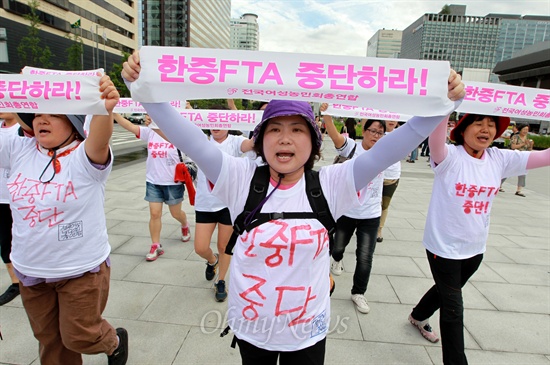 전국여성농민회총연합 소속 여성농민 10여명이 23일 오후 서울 광화문광장에서 '한중FTA 중단하라!"가 적힌 손피켓을 들고 기습시위를 벌이고 있다.