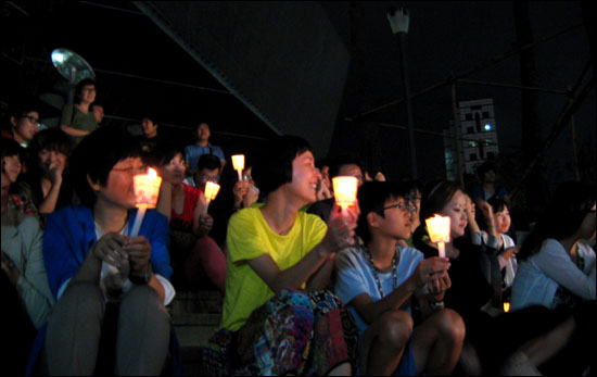 지난 24일 오후 서울 마포구 합정동에서 열린 '경제민주화를 위한 아름다운 동행 시민문화제'에 참석한 한 시민들이 공연을 보고 있다.