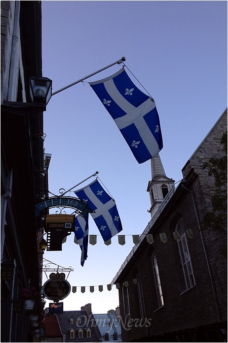 퀘벡주의 옛 시가지. 퀘벡을 상징하는 깃발이 도시 곳곳에 걸려있다. 퀘벡인들은 1960년대 이후 영미계 중심의 사회 문화에 반대해 '조용한 혁명'을 해오고 있다. 