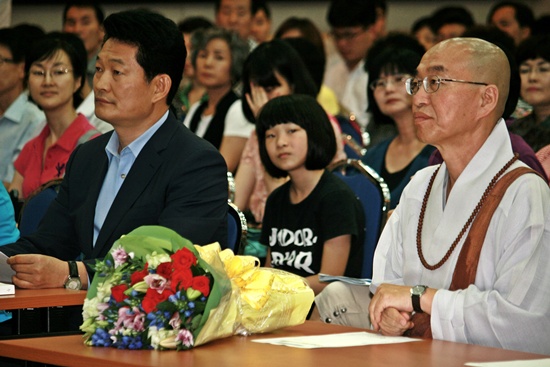 송영길 인천시장(왼쪽)과 법륜 스님이 강연에 앞서 꽃다발을 받고 자리에 함께 앉아있는 모습.