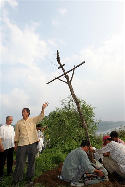 3일 오후 경기도 양평 팔당두무머리에서 마지막 생명평화 미사가 열렸다. 농민들이 3년 동안 미사터에 세워진 십자가 나무를 옮기고 있다.
