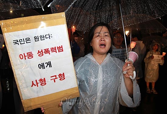 아동 성폭력 추방을 위한 시민모임 '발자국' 한 회원이 4일 오후 서울역 광장에서 열린 촛불집회에 참석해 아동 성범죄자에 대한 사형 구형을 촉구하며 구호를 외치고 있다.