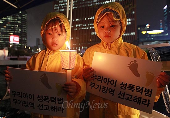 지난 4일 오후 서울역 광장에서 아동 성폭력 추방을 위한 시민모임 '발자국' 주최로 열린 촛불집회에 어머니와 함께 참석한 어린이들이 아동 성범죄자에 대한 처벌 강화를 촉구하는 손피켓을 들어보이고 있다. 