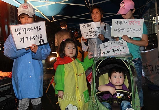 4일 오후 서울역 광장에서 아동 성폭력 추방을 위한 시민모임 '발자국' 주최로 열린 촛불집회에 어머니와 함께 참석한 어린이들이 아동 성범죄자에 대한 처벌 강화를 촉구하며 피켓을 들어보이고 있다.