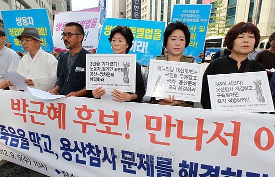 피켓을 들고 박근혜 후보 면담을 요구하는 용산철거민 참사 유가족들.
