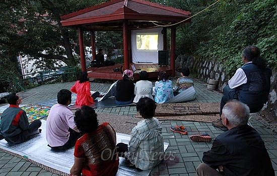 6일 오후 서울 은평구 신사2동 팔각정에서 산새마을 주민 주최로 열린 '별이 빛나는 영화제'에서 마을 주민들이 영화 '최종병기 활'을 관람하고 있다.
