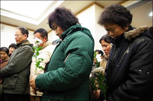 2008년 1월 서울출입국의 단속을 피하려다 추락사 한 중국동포 권봉옥씨 장례식에서 헌화를 기다리고 있는 중국동포들.