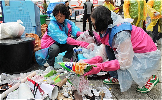  10일 오전 10시부터 200여명이 동원된 부산 서면 특화거리 청소에 참가한 자원봉사자들이 쓰레기를 치우고있다. 