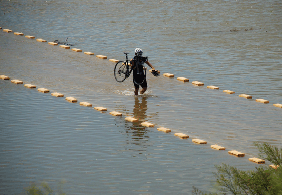 지난 5일 공주시 검상동에 있는 자전거도로가 침수되어 이용객이 자전거를 들고 건너고 있다.
