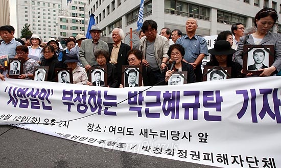 12일 오후 여의도 새누리당사앞에서 열린 '인혁당재건위사건 '사법살인' 부정하는 박근혜 규탄 기자회견'에서 희생자 유가족들이 고인들의 영정사진을 참석하고 있다.