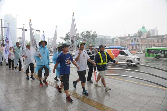 비를 맞으면서 서울역 앞을 지나고 있는 채인석 시장과 일행들