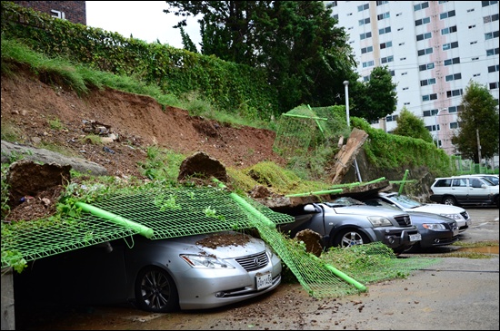 태풍 산바가 뿌린 폭우로 여수시 도원사거리 이레타운 옹벽이 무너져 차량이 덮여 있다.