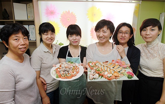 20일 오전 서울 노원구 중계동 청구3차 아파트 관리사무소에서 열린 문화센터 요리 수업에 참가한 주민들이 직접 만든 요리를 들어보이고 있다.