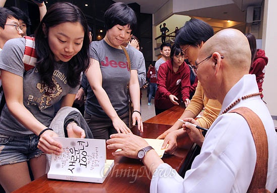 법륜스님이 23일 저녁 서울시립대 대강당에서 열린 <법륜스님ㆍ오연호의 쟁점타파 특별콘서트>를 마친 후 참석자들에게 사인요청을 받고 있다.