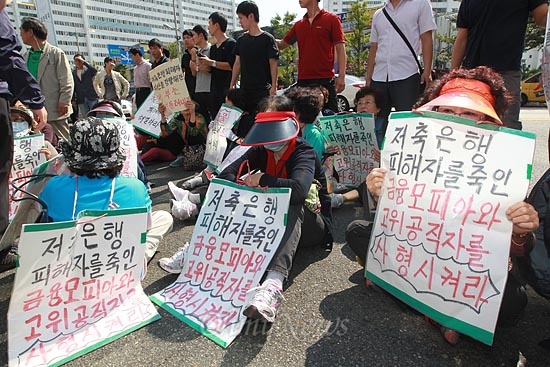 저축은행 피해자들이 24일 오후 부산시 수영구 새누리당 부산시당 앞에서 저축은행 사태에 대해 박근혜 대선후보의 적극적인 자세를 촉구하며 도로를 점거한 채 시위를 벌이고 있다.
