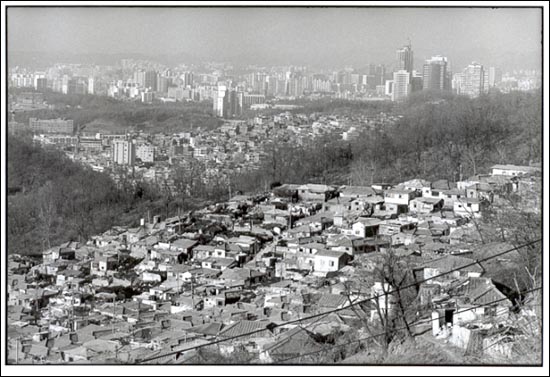  1990년대 관악구 봉천동 판자촌 전경. 따닥따닥 붙은 판자촌은 이웃간의 소통을 가능하게 했다. 옆집에 끼니 굶는 사람이 있으면 함께 밥을 나눠 먹으며 마을을 이룰 수 있었다. 