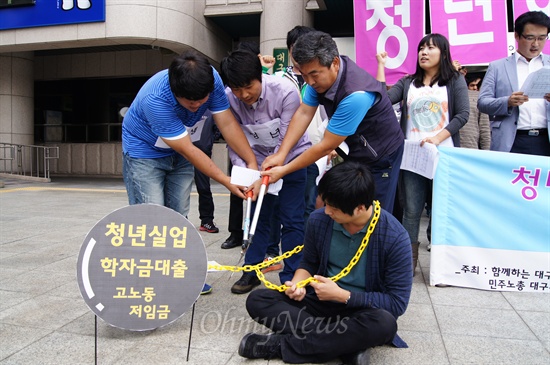  대구시청 앞에서 청년 의제 해결을 촉구하는 기자회견에서 청년실업과 학자금 대출, 고노동 저임금 등의 사슬을 끊는 퍼포먼스를 하고 잇다.