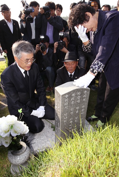 문재인 대통령이 지난 2012년 9월 28일 광주 국립5.18민주묘지의 고 문재학군의 묘를 찾아 유가족들을 위로하고 있다.