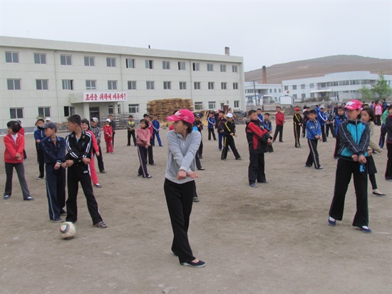 나진에 있는 외국어 중학교. 학생들이 체육수업을 받고 있다. 학생들이 영어가 적혀 있는 모자를 쓰고 있다.