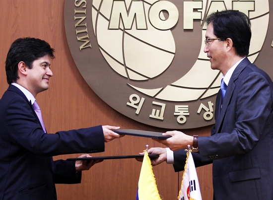  이윤영 외교통상부 FTA교섭국장과 하비에르 감보아(Javier Gamboa) 콜롬비아 통상산업관광부 FTA교섭대표가 8월 31일 서울 도렴동 외교통상부에서 한-콜롬비아 FTA 가서명을 마친 뒤 문서를 교환하고 있다. 콜롬비아는 미국, EU, 캐나다 등 18개국과 FTA를 체결했고 현재 4개국과 협상 중이며 아시아 국가 중에는 한국과 처음으로 FTA 협상을 타결했다.
