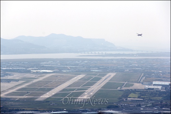 신어산에서 바라본 김해공항 활주로 전경. 낙동강 하구언이 멀리 보인다.