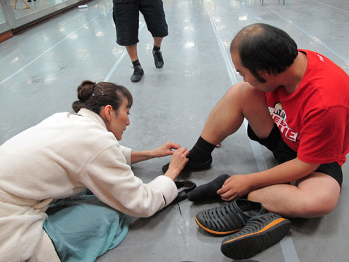 발레공연 주인공 무용수가 빅이슈 아저씨의 신발끈 묶는 걸 도와주고 있다. 