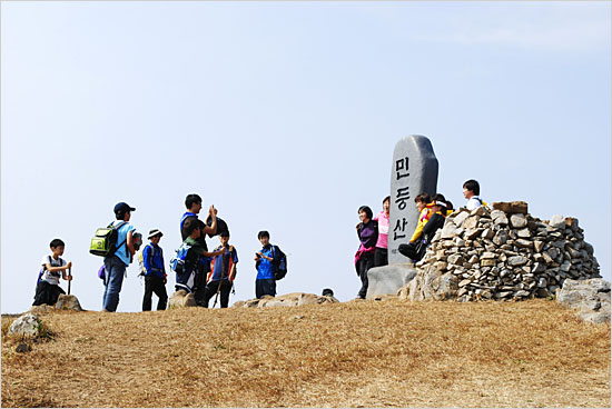 민둥산 정상 표지석을 안고 기념사진을 찍는 등산객들.