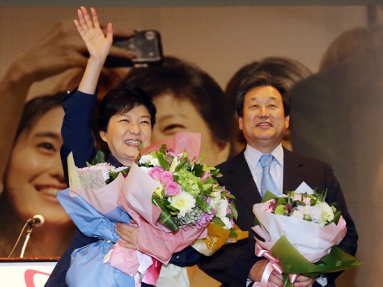 새누리당 박근혜 대선후보와 김무성 총괄선대본부장이 2012년 10월 11일 오후 서울 당산동 그랜드컨벤션센터에서 열린 중앙선대위 워크숍에서 꽃다발을 받은 뒤 손을 흔들고 있다.