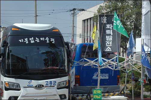 고흥군청 앞에 세워진 고흥군 버스 '지붕없는 미술관'과 '화력발전소 근조'를 비롯한 화력발전소 반대 대책위의 깃발들이 묘한 조화를 이루고 있다.