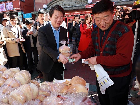 안철수 무소속 대선후보가 23일 오전 인천 북성동 차이나타운을 찾아 한 상인으로부터 공갈빵을 사고 있다.