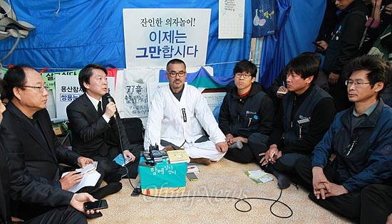 안철수 무소속 대선후보가 김정우 쌍용자동차 지부장을 비롯한 해고노동자들을 위로하고 있다.