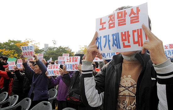 김만수 부천시장의 환영사가 시작되자 전국노점상총연합 회원들이 김 시장의 노점상 정책에 반대하는 피켓을 들고 침묵시위를 벌이고 있다.