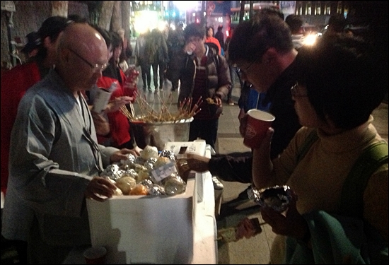 26일 덕수궁 대한문에서 열린 '희망밥콘서트'에 참석한 시민들이 주먹밥과 어묵을 먹고 있다.
