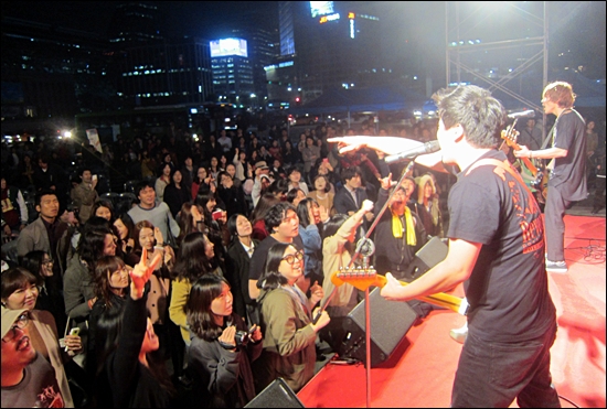 26일 덕수궁 대한문에서 열린 '희망밥콘서트'에서 록밴드 옐로우몬스터즈의 공연에 맞춰 참가자들이 호응하고 있다.