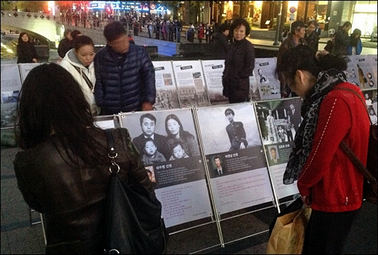28일 '유신시대 금지곡 전국 노래자랑'이 개최된 서울 청계광장에서 시민들이 유신시대 벌어졌던 인혁당 사건과 관련된 전시물을 보고 있다.