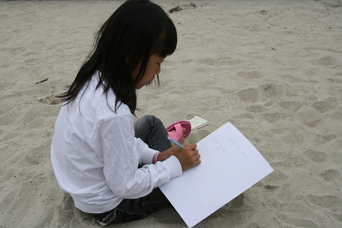 섬사랑시인학교 해변백일장에 참가한 한 초등학생의 모습