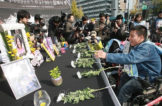  광화문광장에서 열린 뇌성마비 중증장애인 김주영씨의 노제에 참여한 장애인들이 헌화하고 있다.