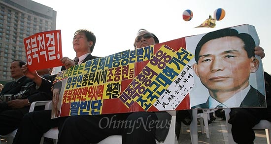  30일 오후 서울광장에서 열린 국민행동본부 주최 '대한민국의 생명선 NLL 포기 음모 규탄 국민궐기대회'에서 한 참가자가 "박정희 대통령 본 받자"는 구호와 사진이 실린 손피켓을 흔들고 있다.