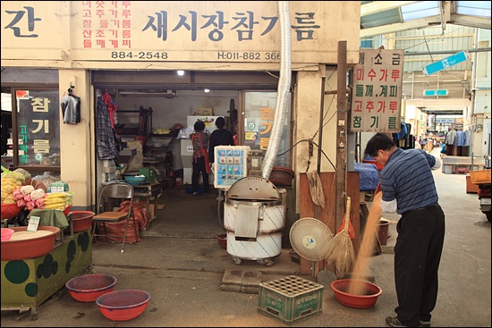 하동시장번영회 회장 김주환 씨가 그의 가게 앞에서 참깨 껍질을 날리고 있다.