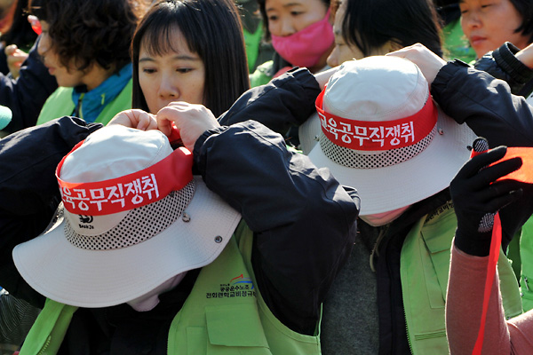 '학교 비정규직 노동자대회'에 참석한 참가자들이 '교육 공무직 쟁취'라고 씌어진 머리띠를 묶고 있다.